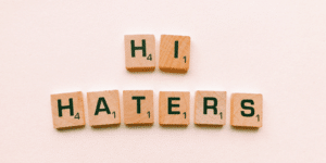 Scrabble tiles that spell out hi haters