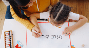 a woman who is a teachr teaching kid to write
