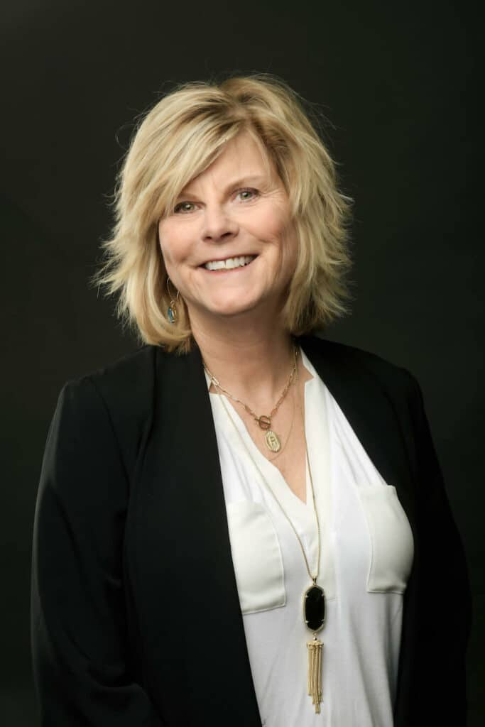 Dr. Robin Burr wearing black coat and white inner top